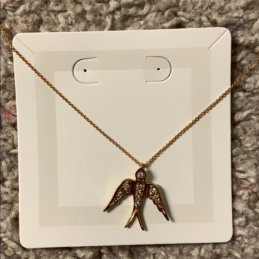 Gold bird necklace with cubic zirconia studs.